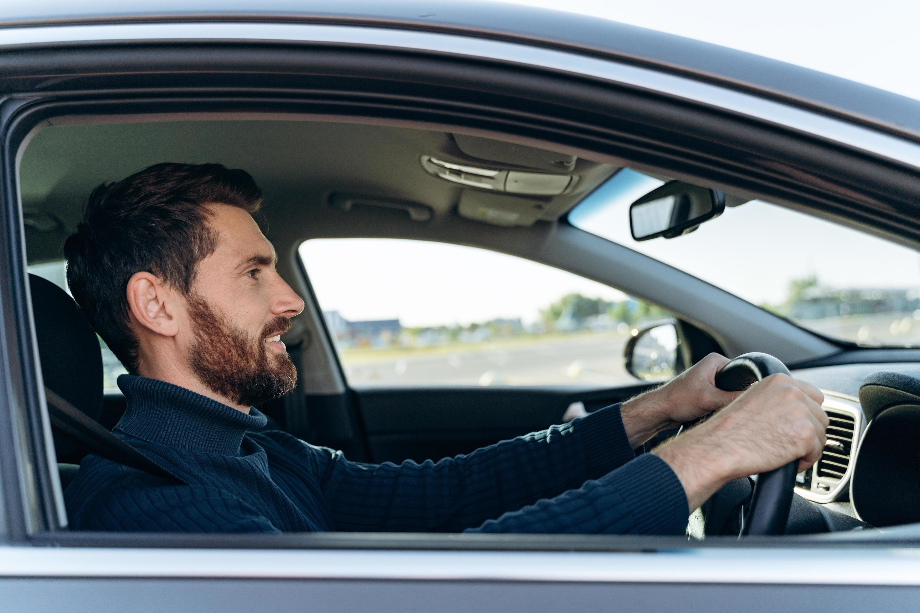 Side View Of The Handsome Businessman Driving Car Before Buying