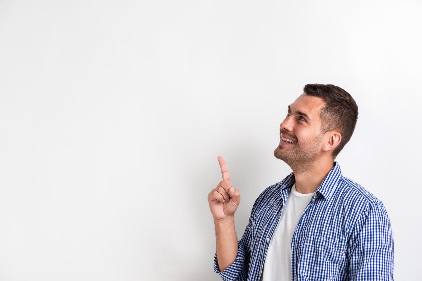 Man pointing his index finger up on empty copy space in the studio . - Image photo