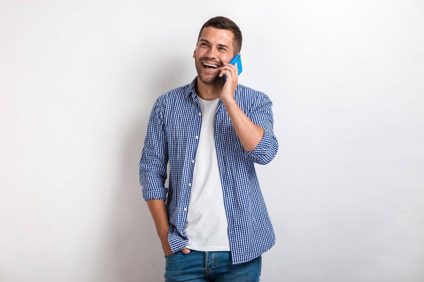 hombre riendo hablando con un teléfono inteligente y mirando hacia arriba.- imagen foto