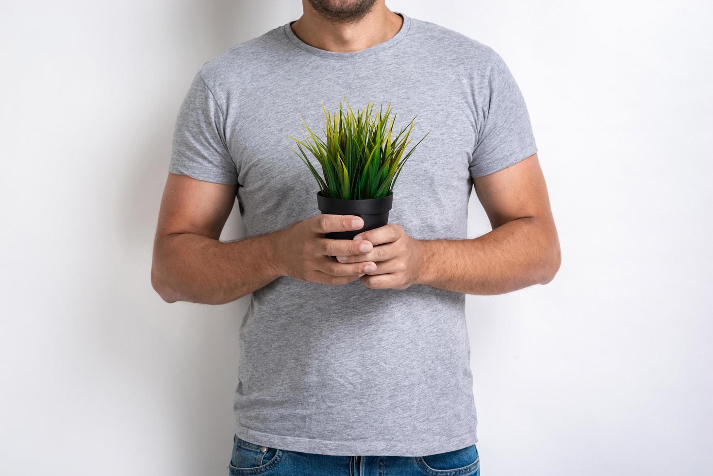 Cropping image - Man with fresh grass pot in his hands .Concept World Environment Day photo