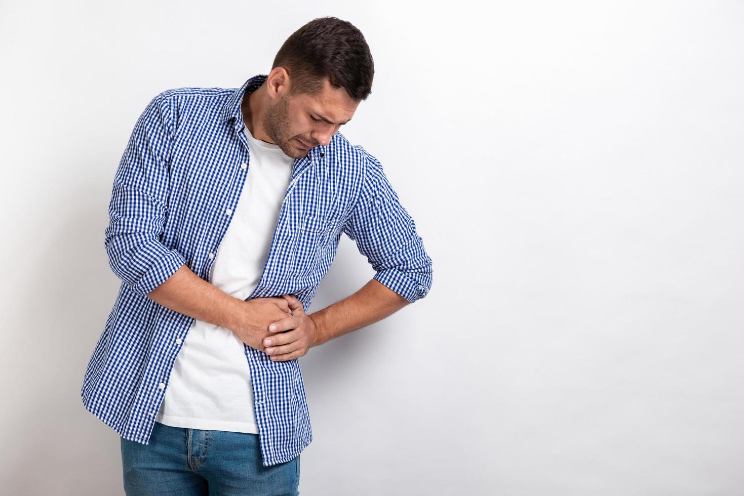 Hombre enfermo con dolor abdominal, sosteniendo el estómago al lado foto