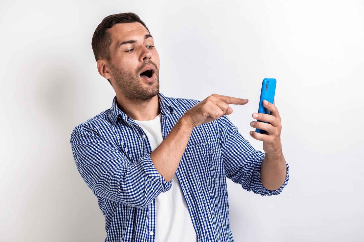 Closeup portrait of wonder man pointing to a smartphone screen .- Image photo