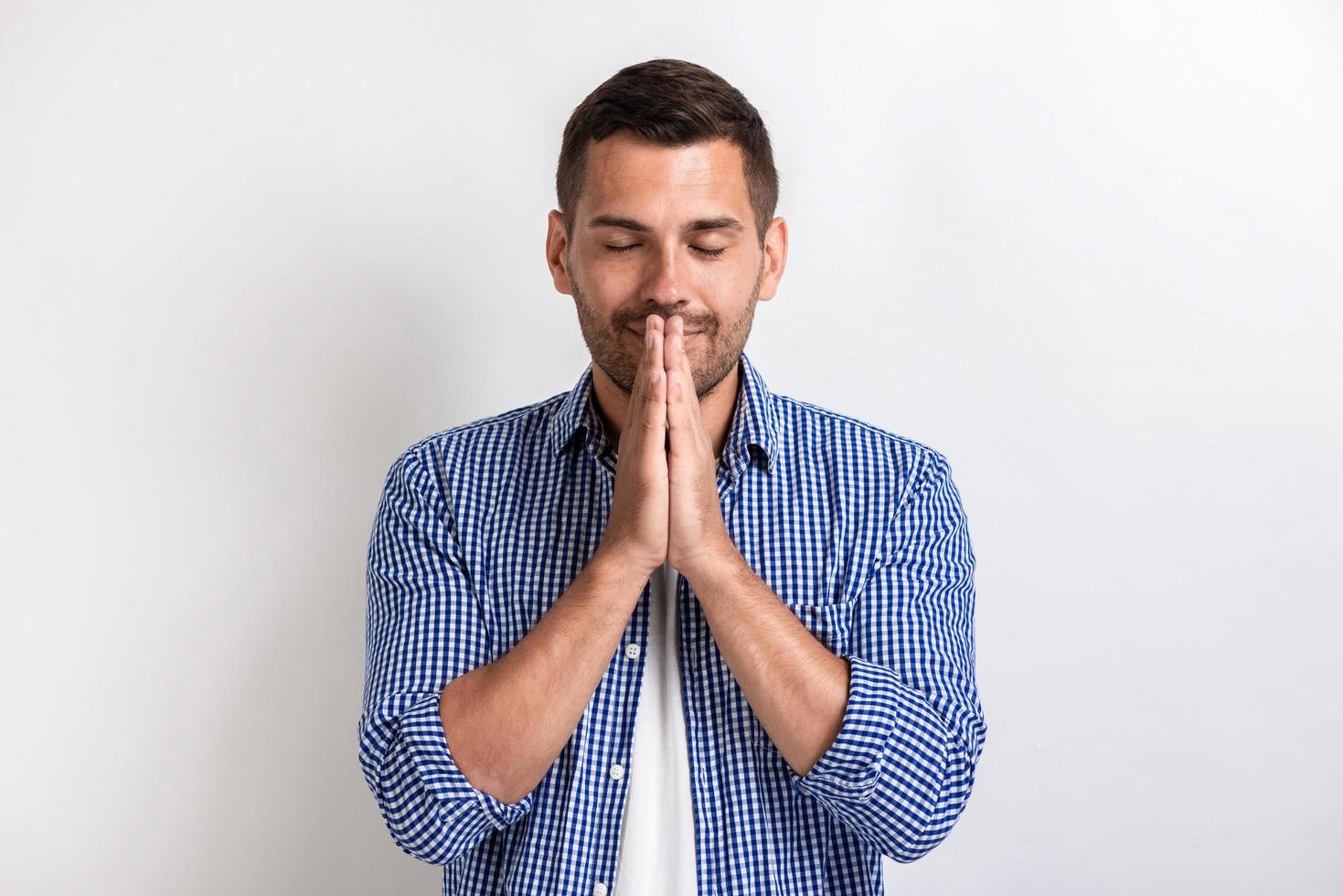 Closeup portrait of handsome man makes a gesture of prayer.- Concept gesture photo