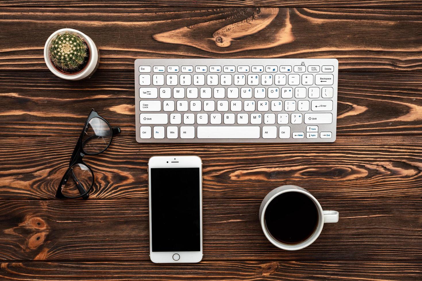 Top view office desk with a cup of coffee and smartphone photo