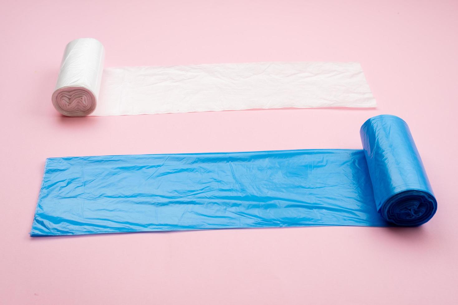 blue and white garbage bag isolated on a pink background photo