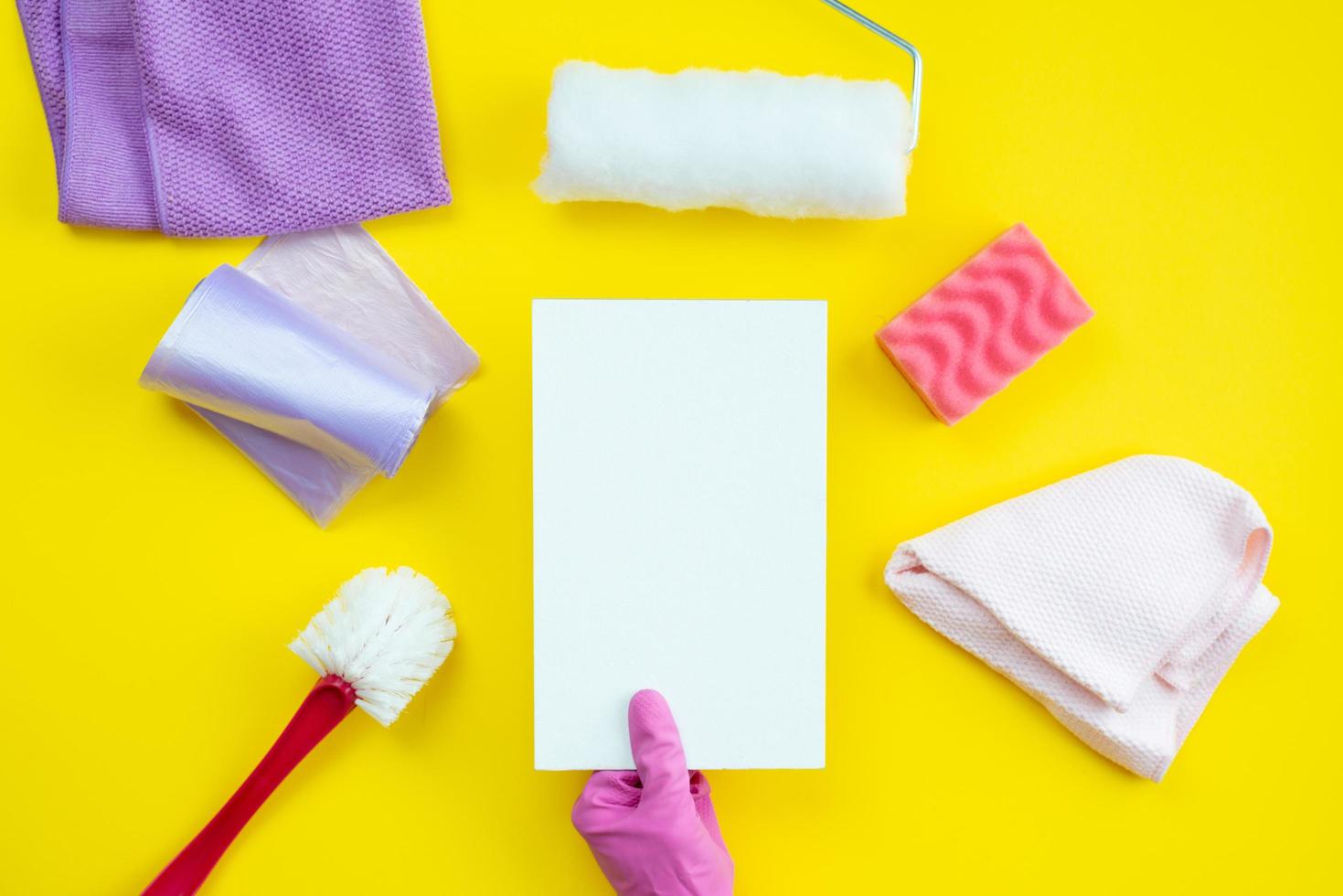 Cleaning items and a clean layout lie on a yellow background. Cleaning service concept. photo