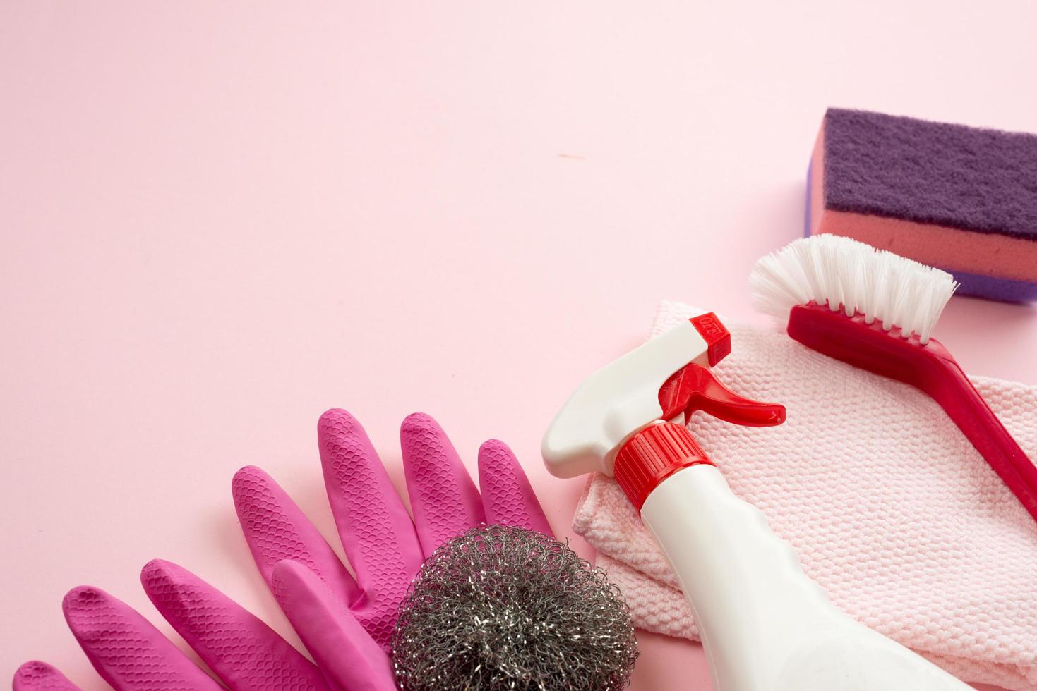 los accesorios del hogar yacen sobre una superficie plana, paño, cepillo de limpieza, guantes de látex, spray, raspador foto