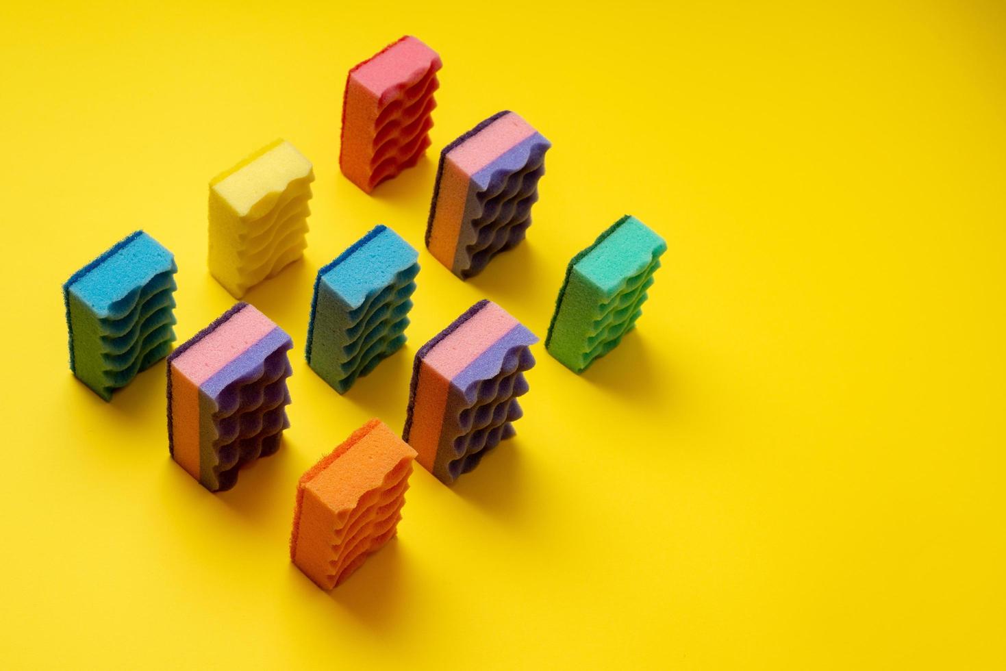 Army of colored washcloths arranged on a yellow background. photo