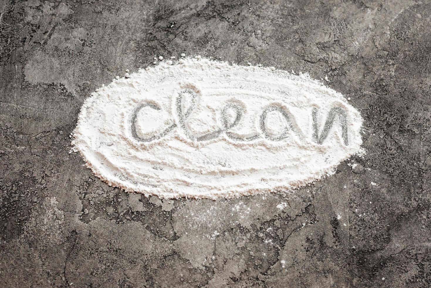 Scattered flour in form oval with inscription clean on a gray decorative plaster background. photo