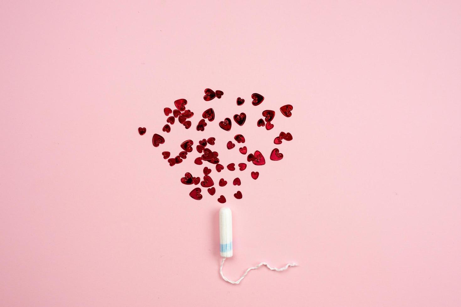 Tampon with hearts on a pink background. photo