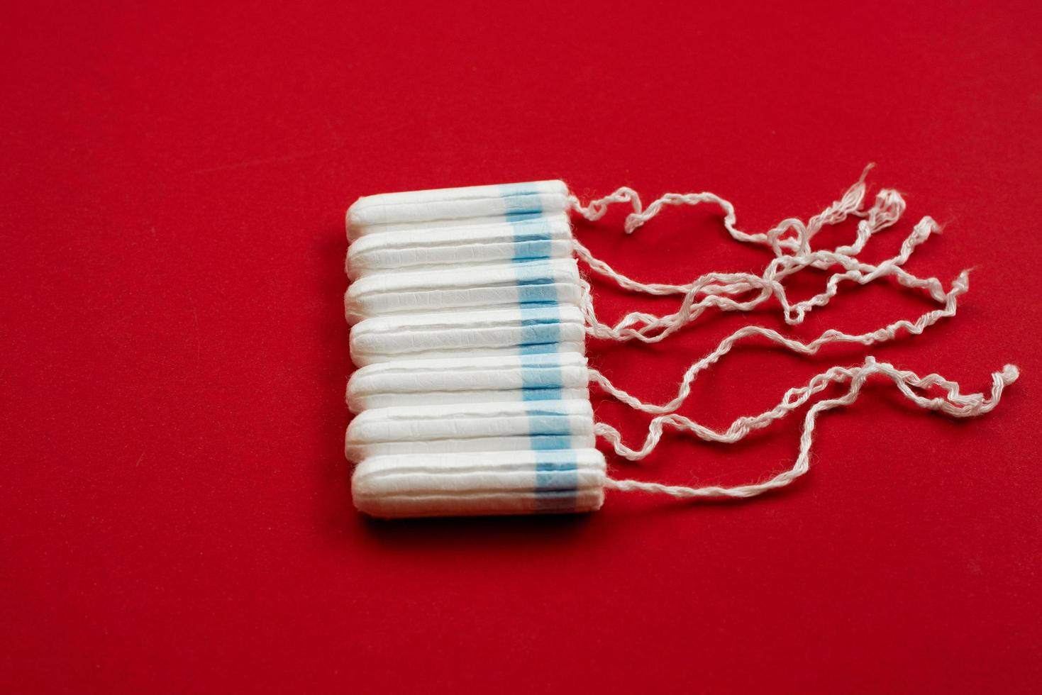 Hygienic women's tampons on a red background, cotton swabs on the right, menstruation. photo