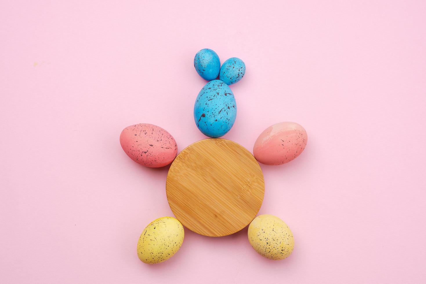 Primer plano de un conejo hecho de huevos y un círculo de madera sobre la mesa. concepto de pascua foto