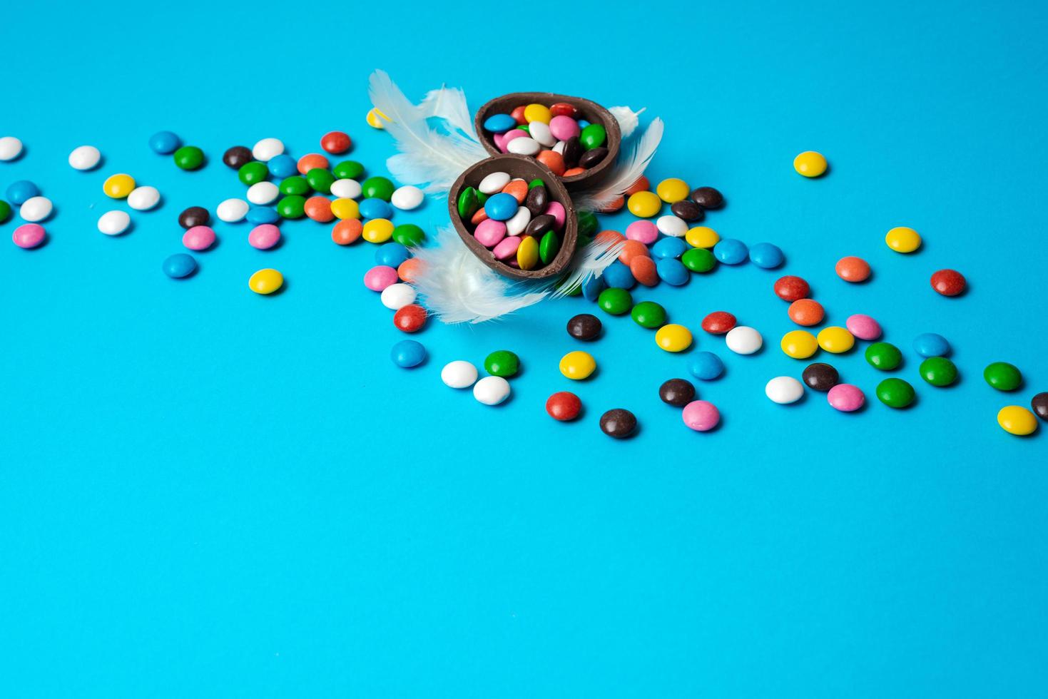 Delicious chocolate easter eggs, sweets on blue background photo