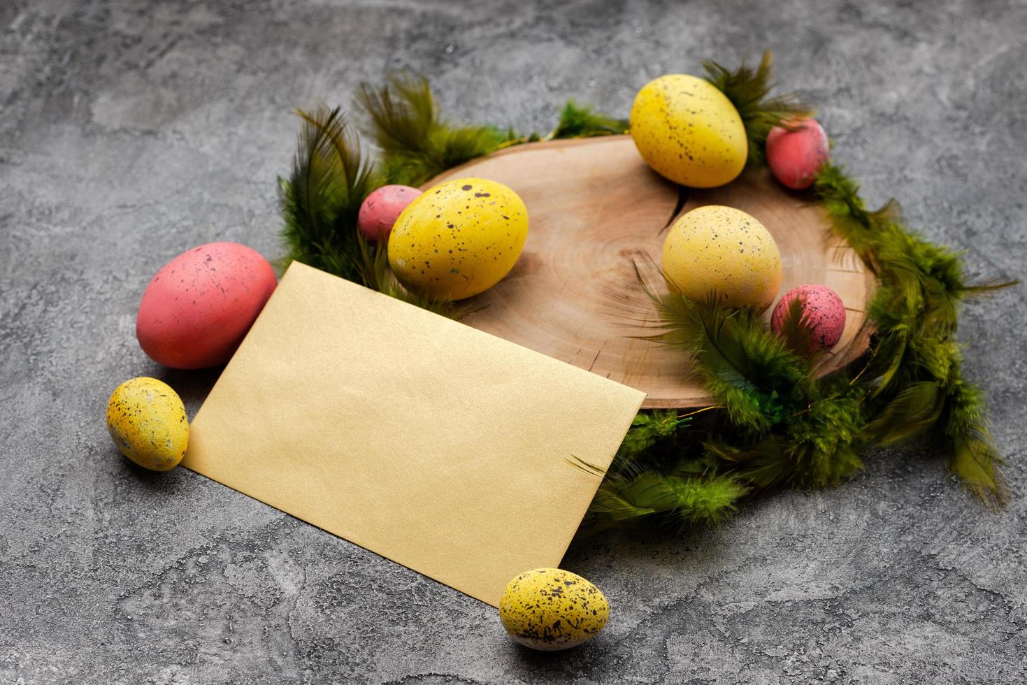 Empty mockup  blank on a  Easter background. Colorful eggs and feathers on the wooden stump. - Copyspace photo