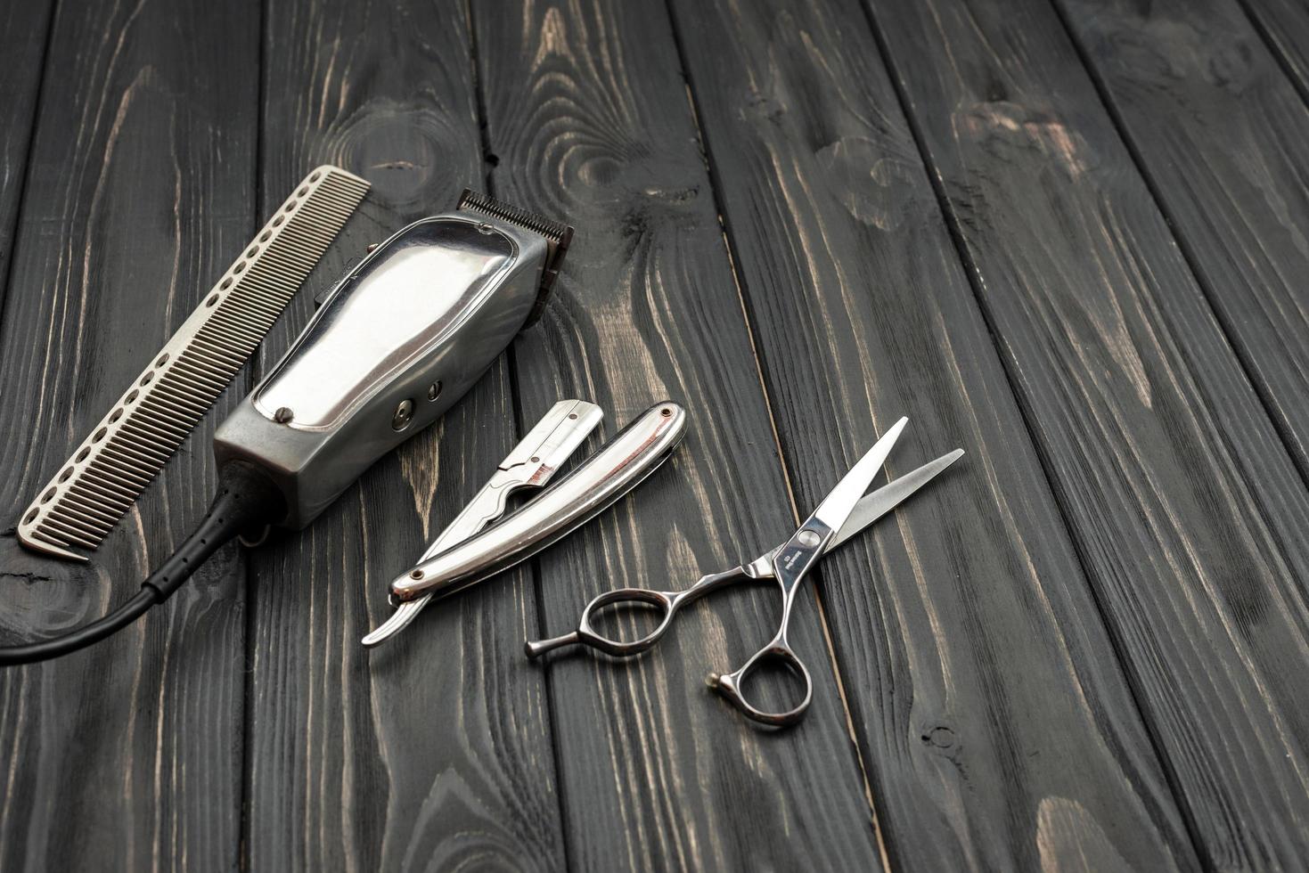herramientas de corte de pelo de los hombres sobre un fondo oscuro de madera. foto