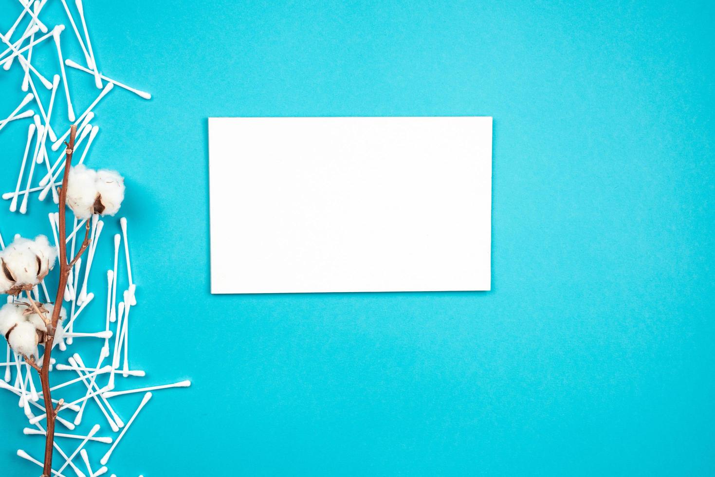 Blank sheet, cotton and ear sticks on blue background. place for advertising, copy space. photo