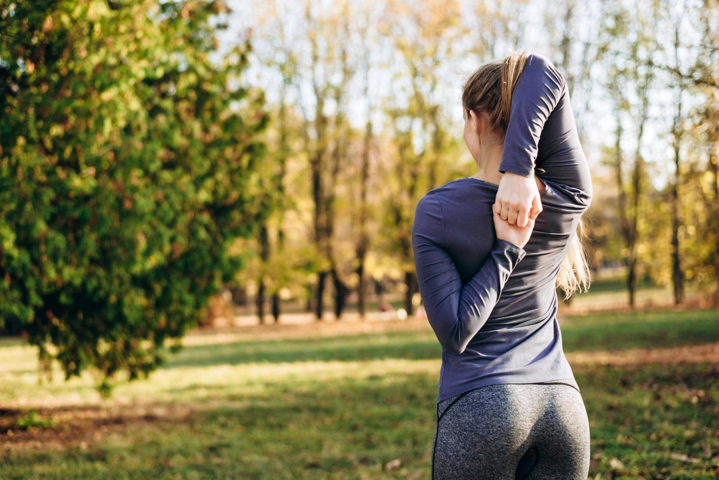 Slender girl from the back holds hands in the castle, training in nature. photo