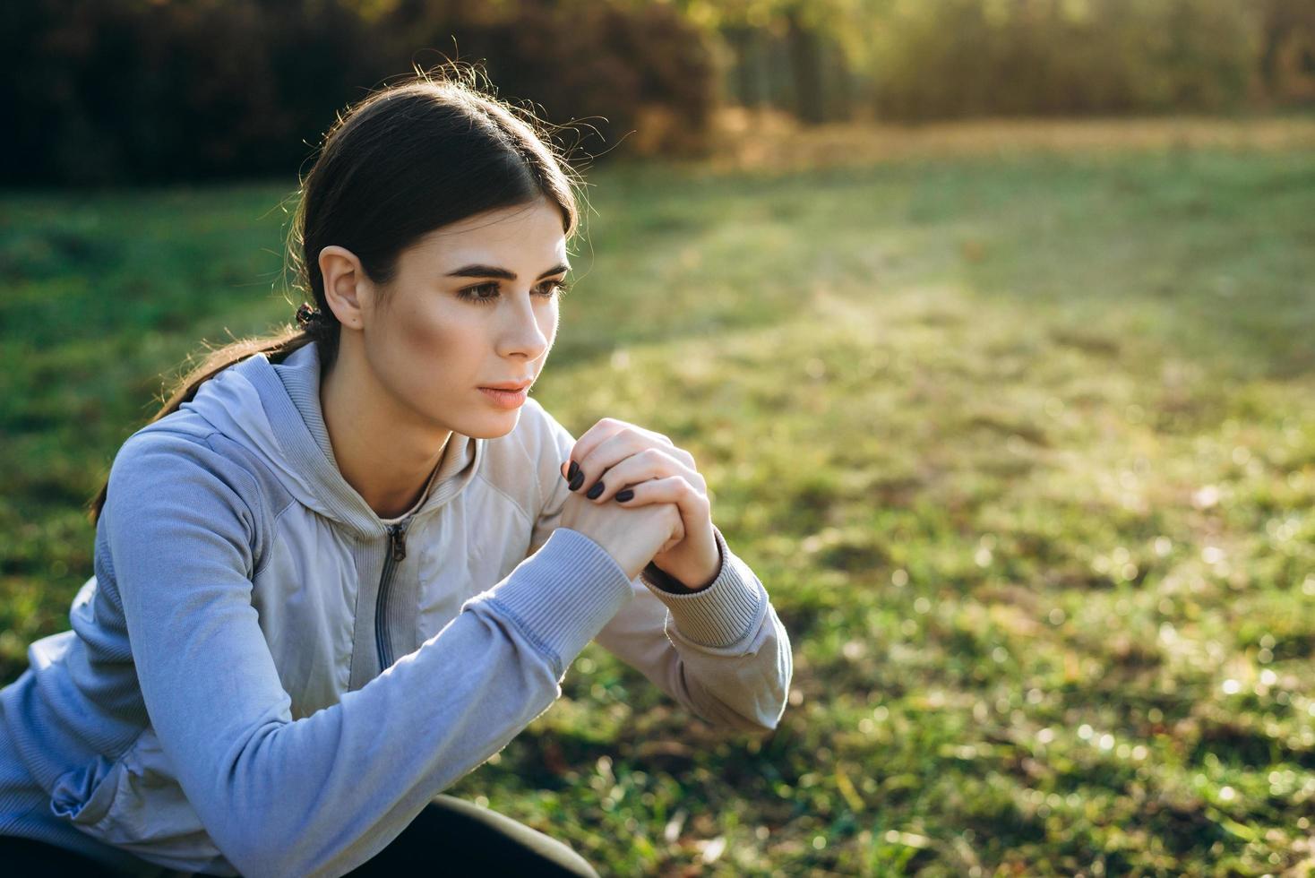 hermosa joven realiza sentadillas al aire libre en un día soleado. de cerca. foto