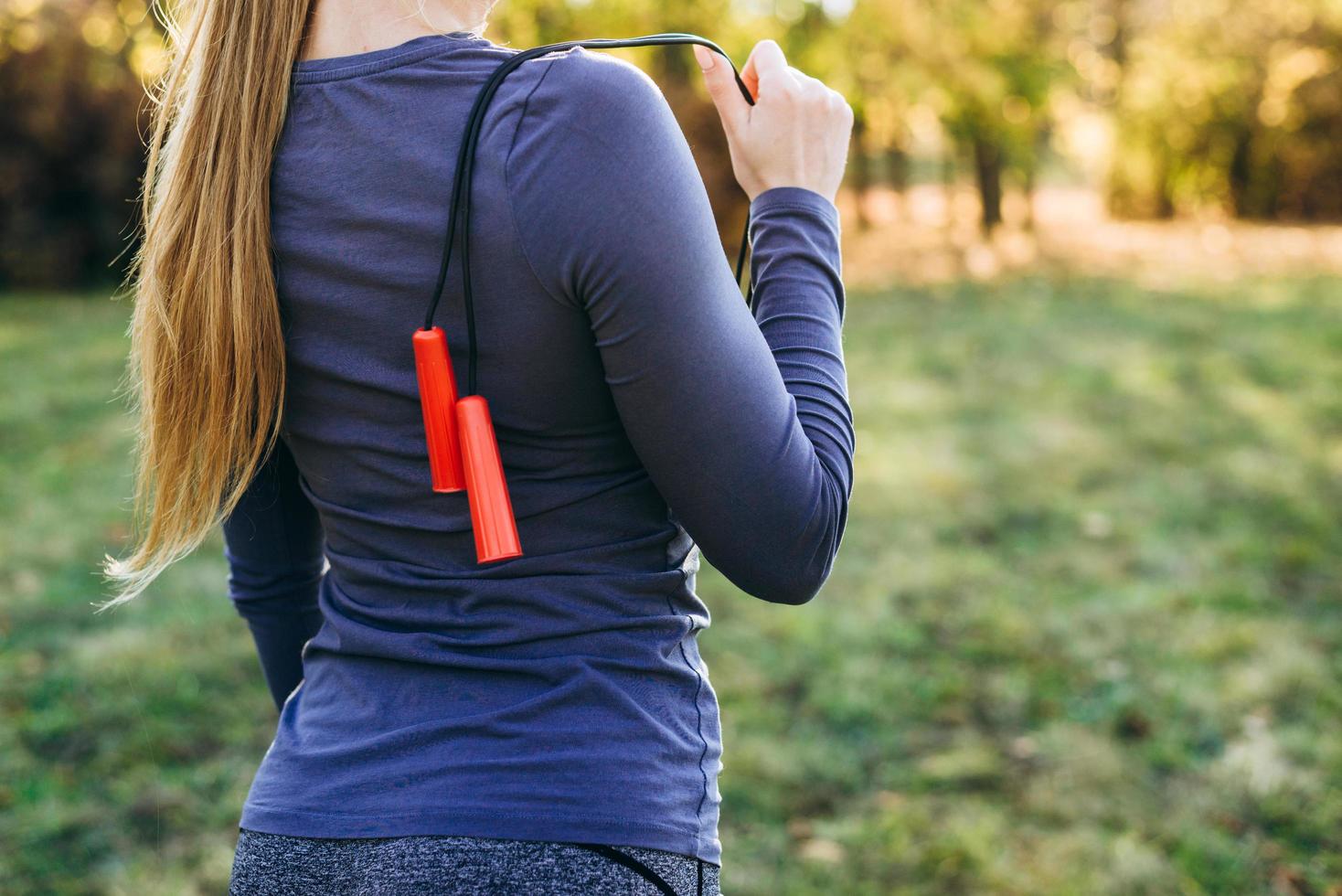 Cropped look, skipping rope on girl's shoulders. photo