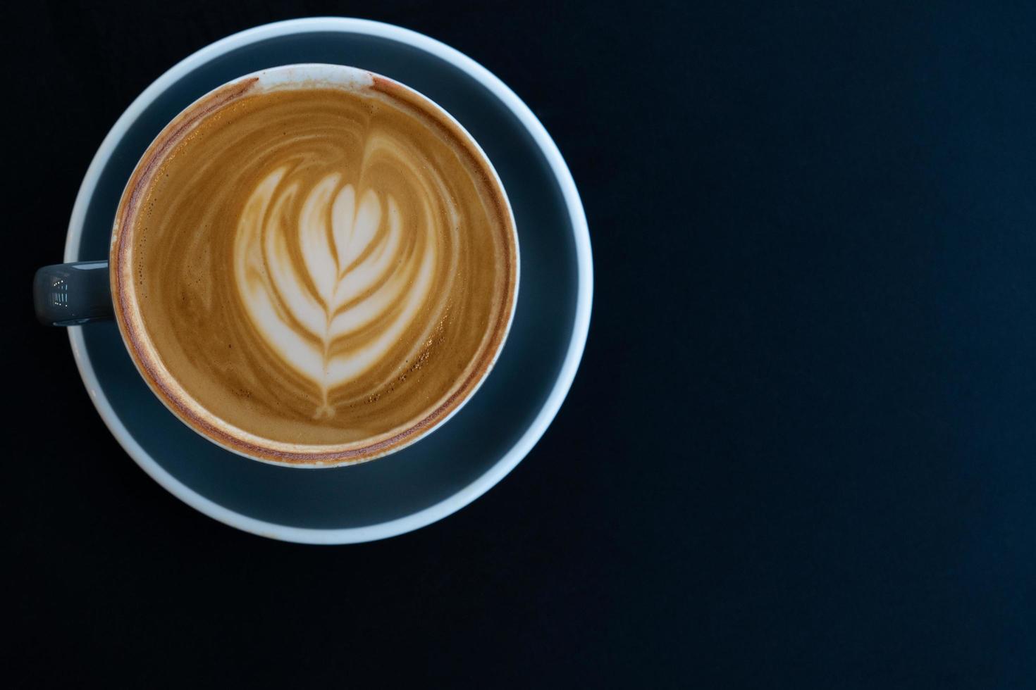 Coffee art latte in cup on blue table ready for breakfast photo