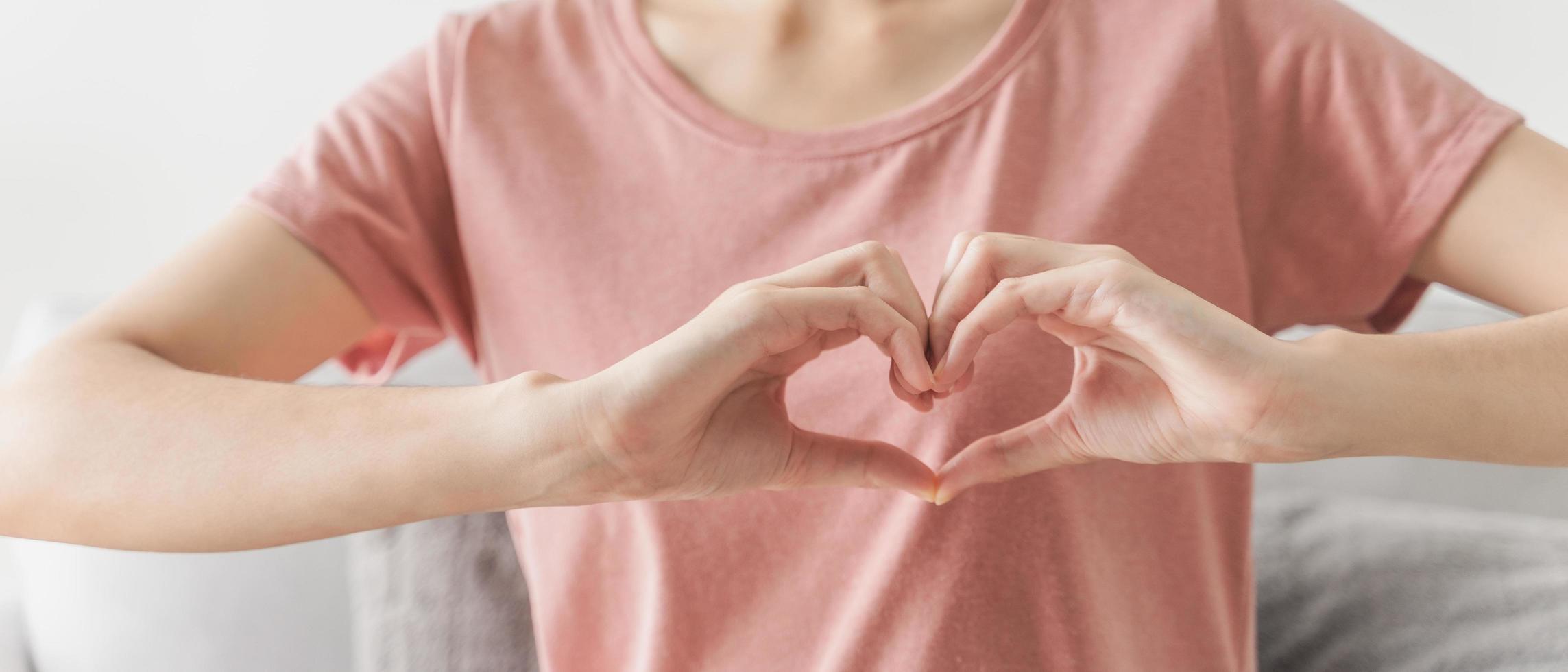 Woman making hands in heart shape, Love, heart health insurance, social responsibility, donation, happy charity volunteer, world heart day, appreciate, world mental health, cancer day photo