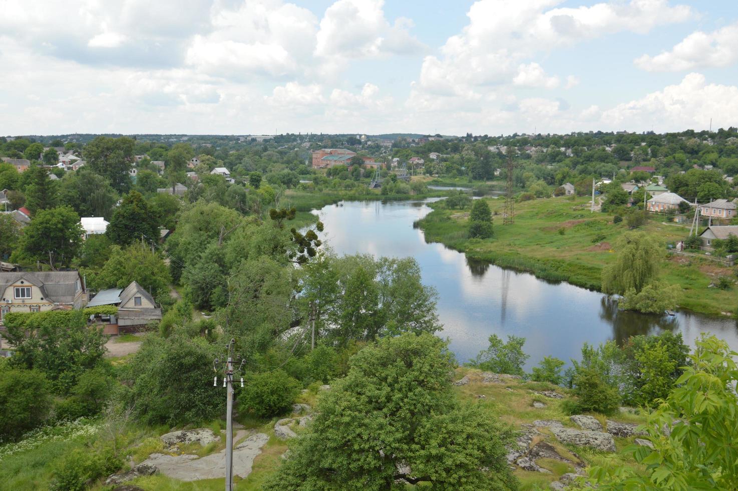 Panorama de la pequeña ciudad con río y casas. foto