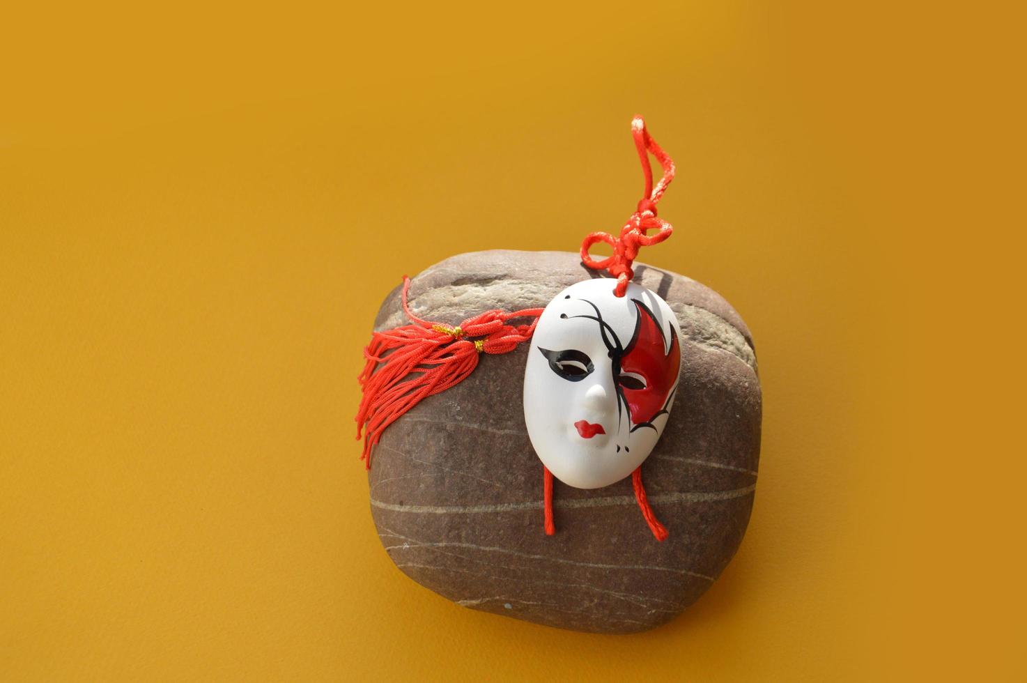 Mysterious carnival mask with objects on a yellow background photo