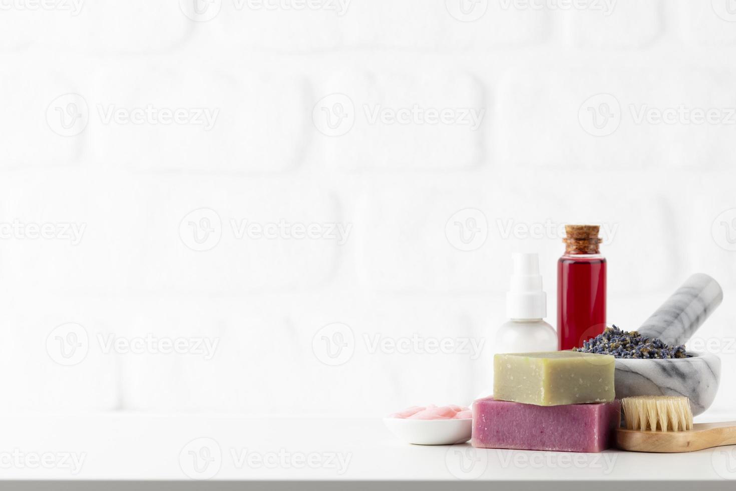 Botellas de cosméticos y jabón artesanal natural sobre fondo blanco. foto