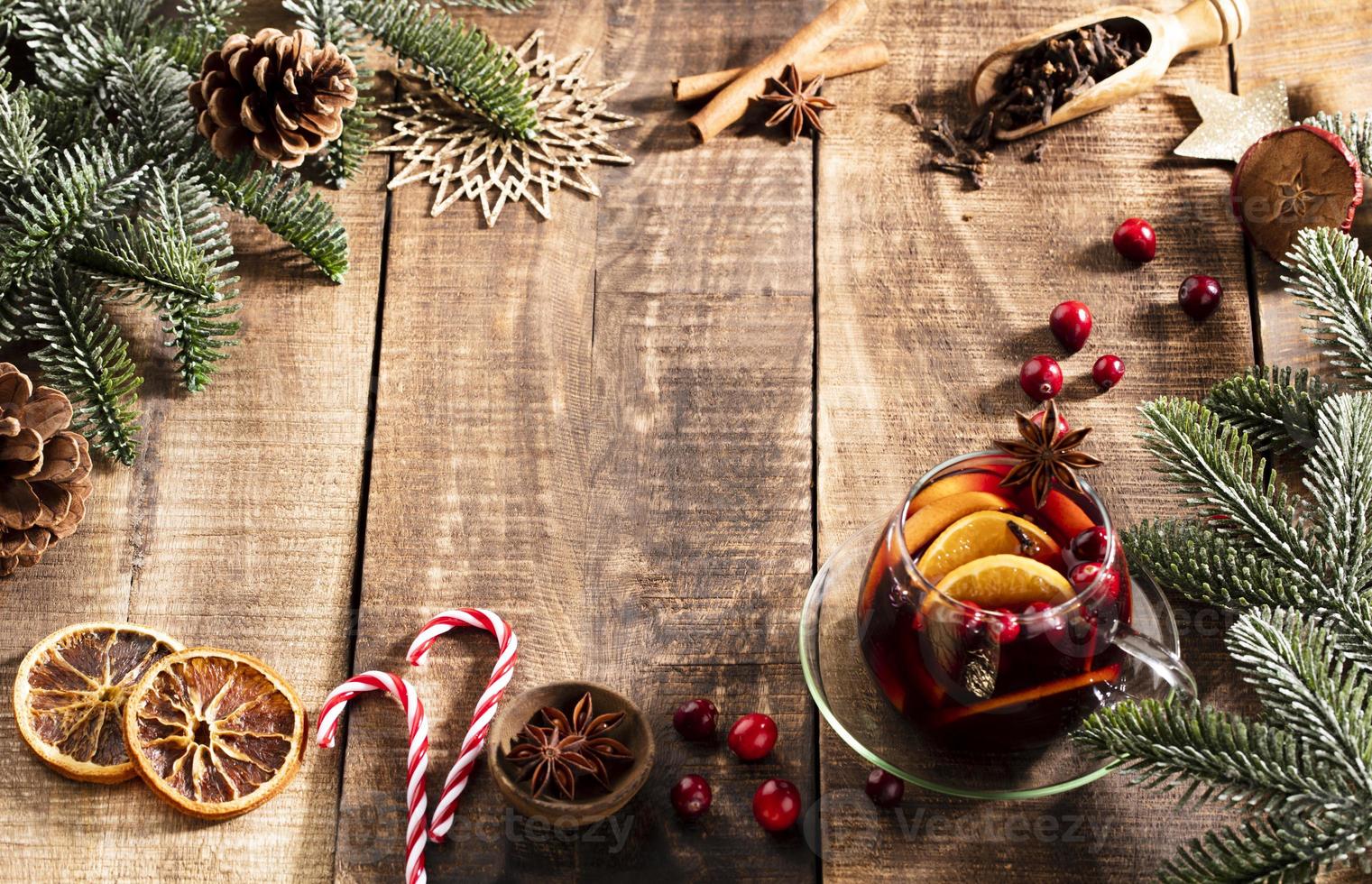 Navidad vino caliente con especias en una mesa rústica de madera. foto