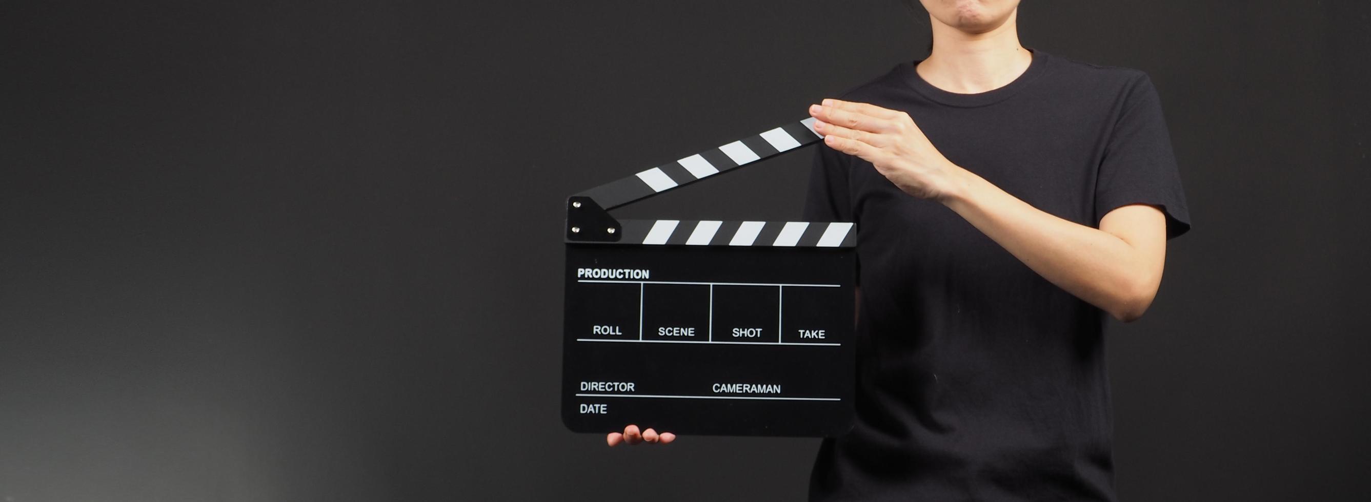 Hand's holding yellow and black Clapperboard or movie slate use in video production ,film, cinema industry on black background. photo