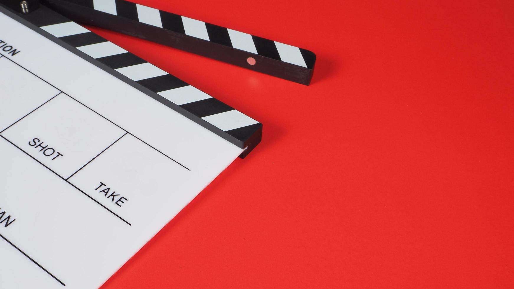 Clapperboard or movie slate. it use in video production ,film, cinema industry on red background. photo