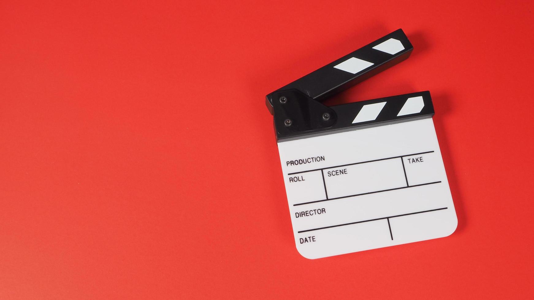 Clapperboard or movie slate. it use in video production ,film, cinema industry on red background. photo