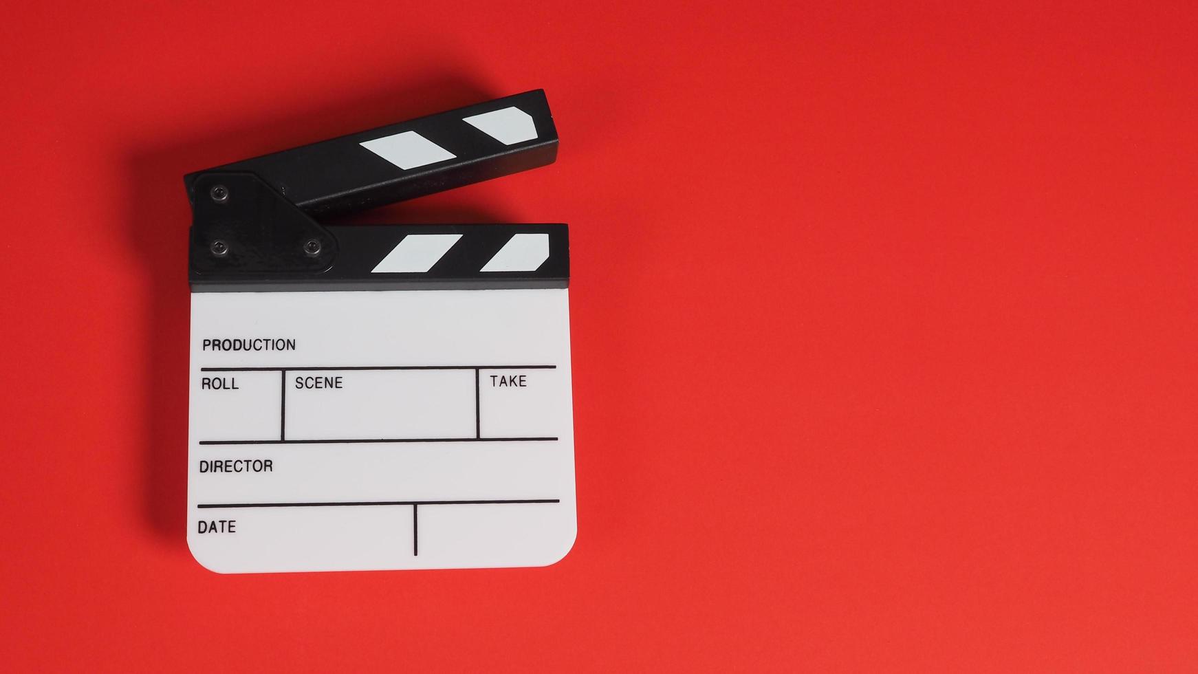 Clapperboard or movie slate. it use in video production ,film, cinema industry on red background. photo