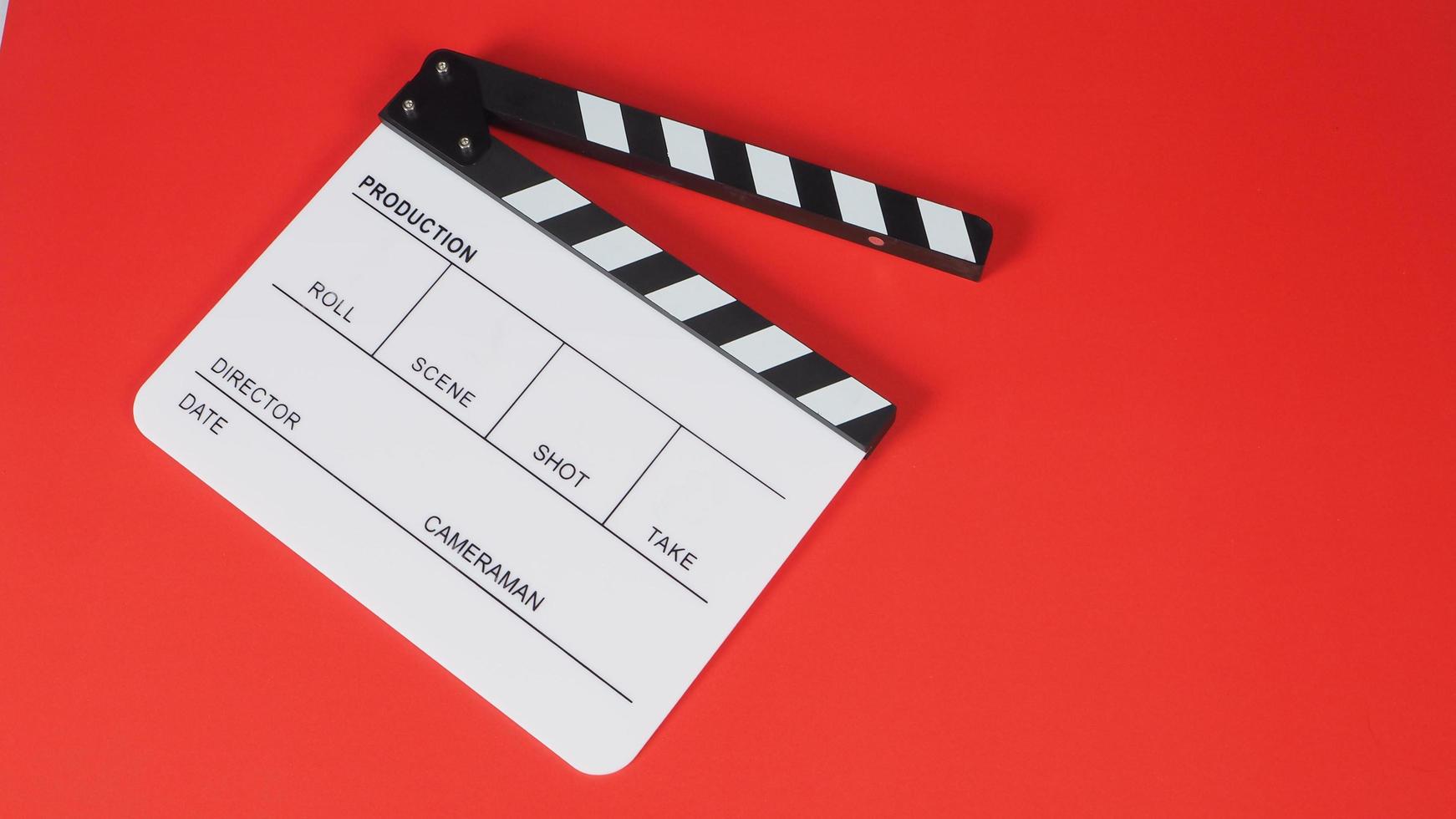 claqueta o pizarra de película sobre fondo rojo.Se utiliza en la producción de videos y la industria cinematográfica. foto