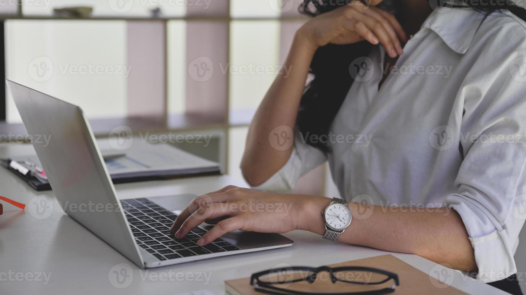 mujer de negocios que usa la computadora portátil para buscar información mientras trabaja desde casa. foto