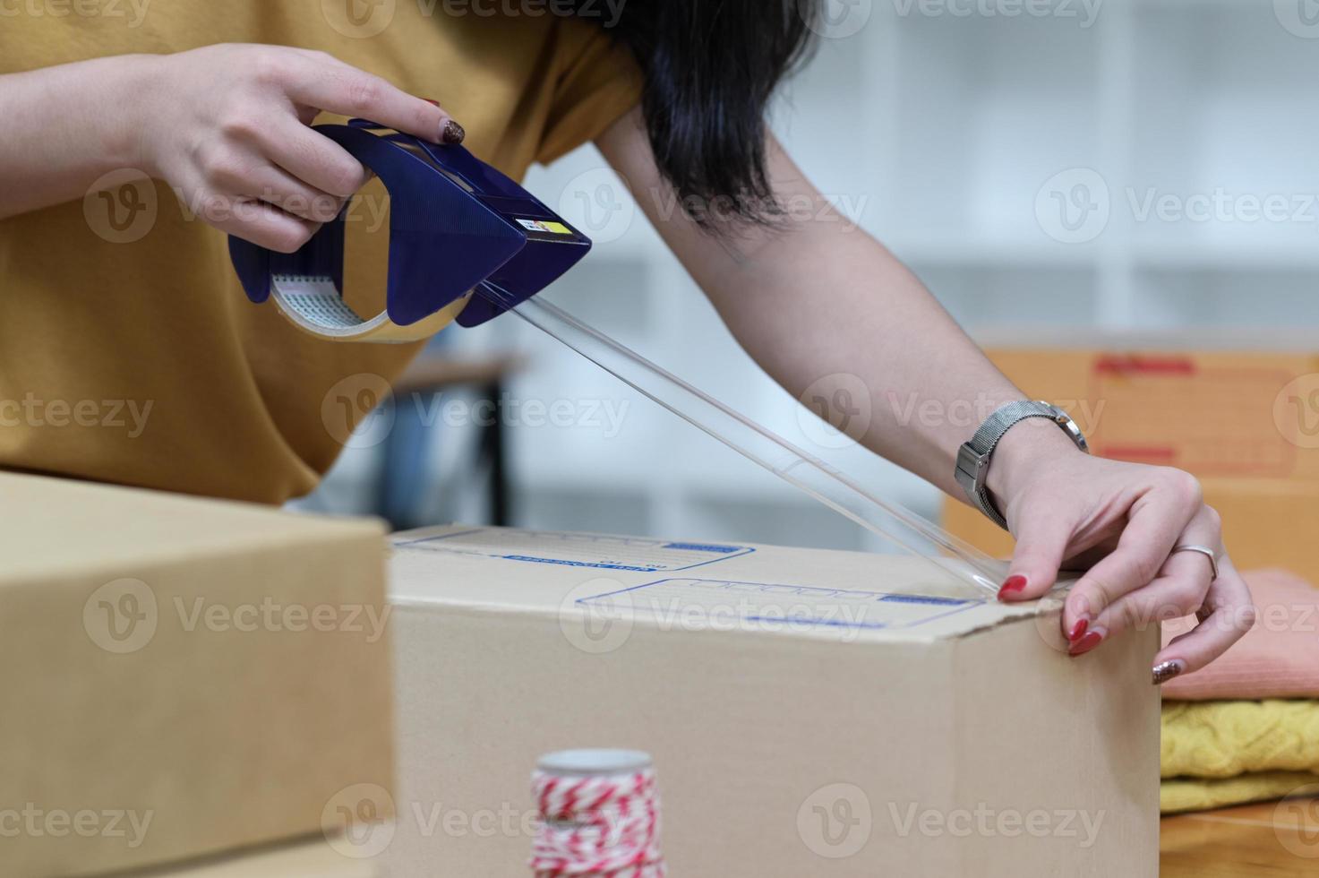 The seller is packing boxes to prepare for shipping. photo