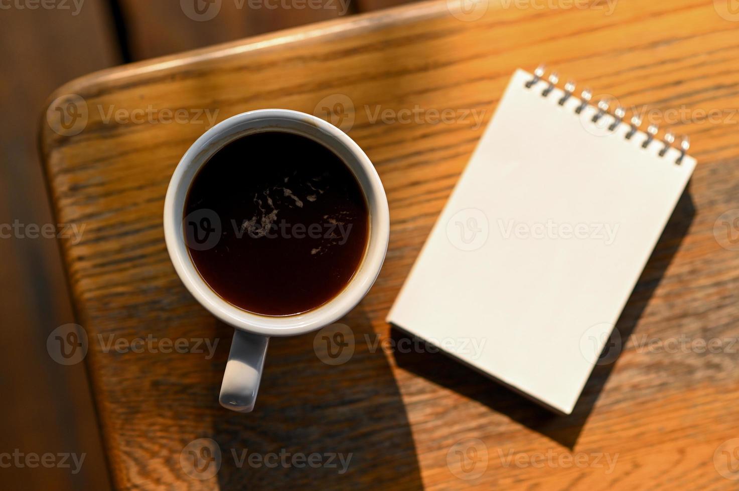 café y un cuaderno sobre la mesa, vista superior. foto