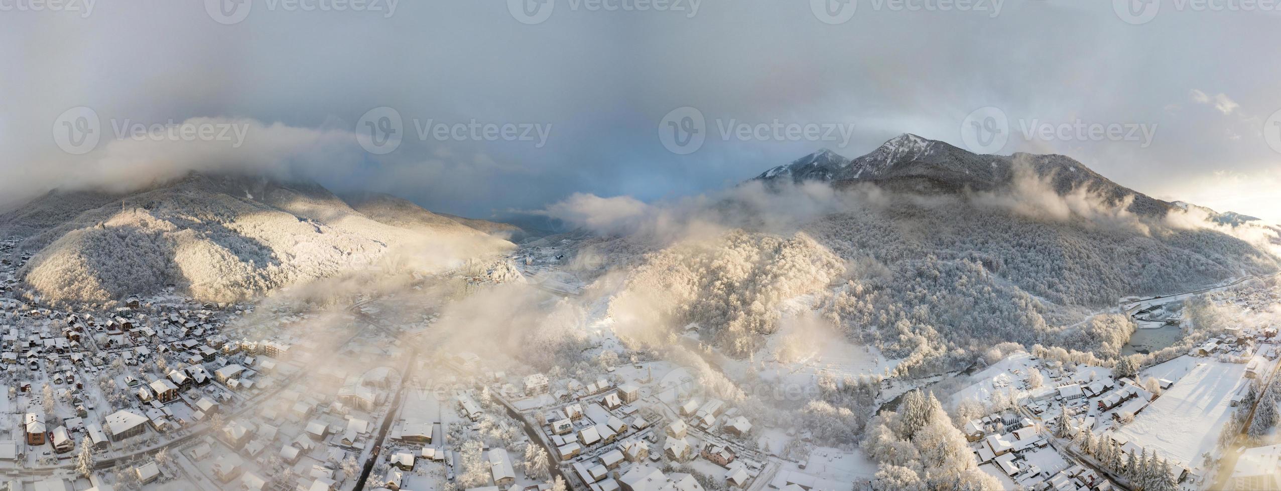 vista aérea de krasnaya polyana, montañas cubiertas de nieve y hermosas nubes. Rusia. foto