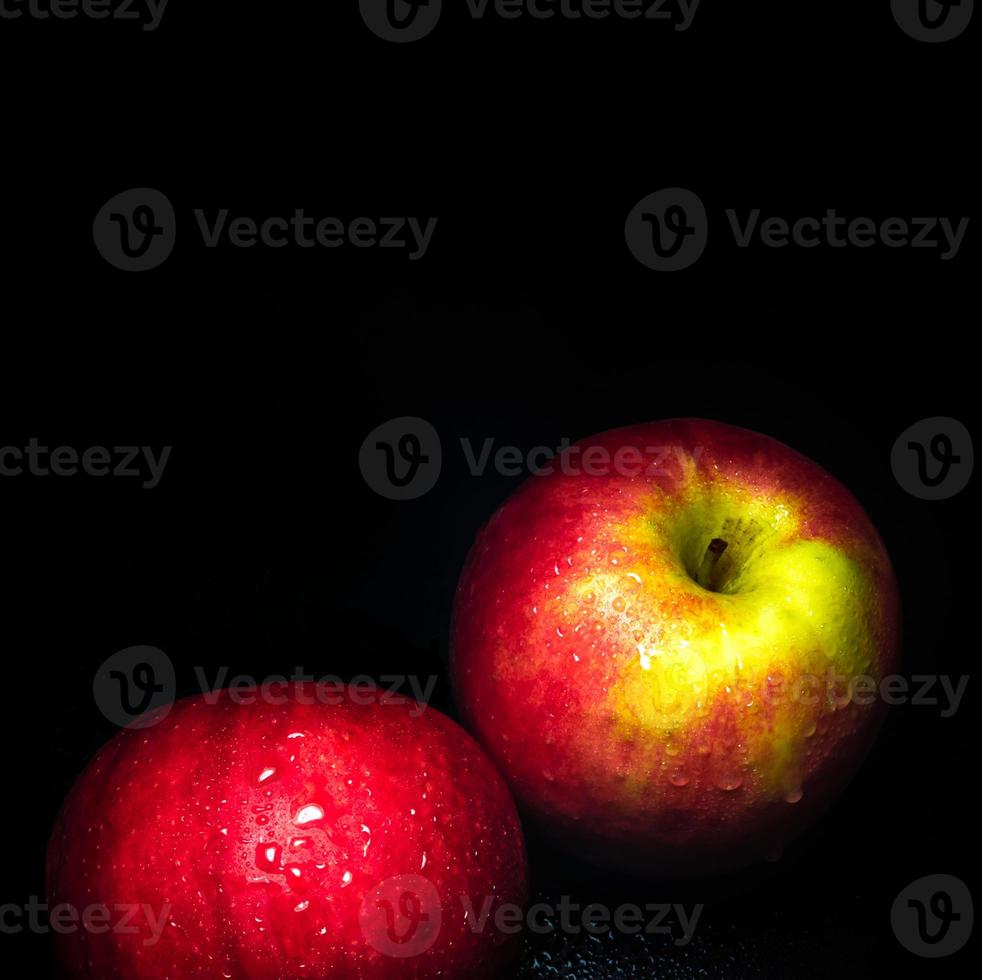 Water droplet on glossy surface of red apple on black background photo