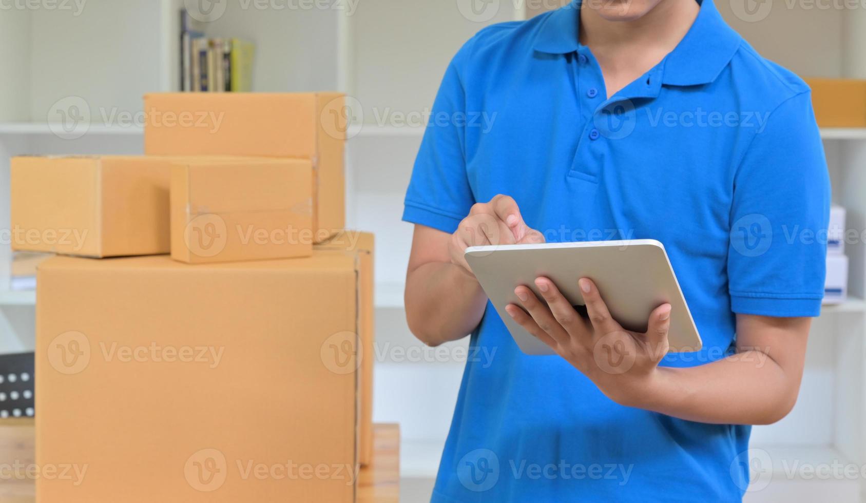 The courier is using a tablet to record the delivery information. photo