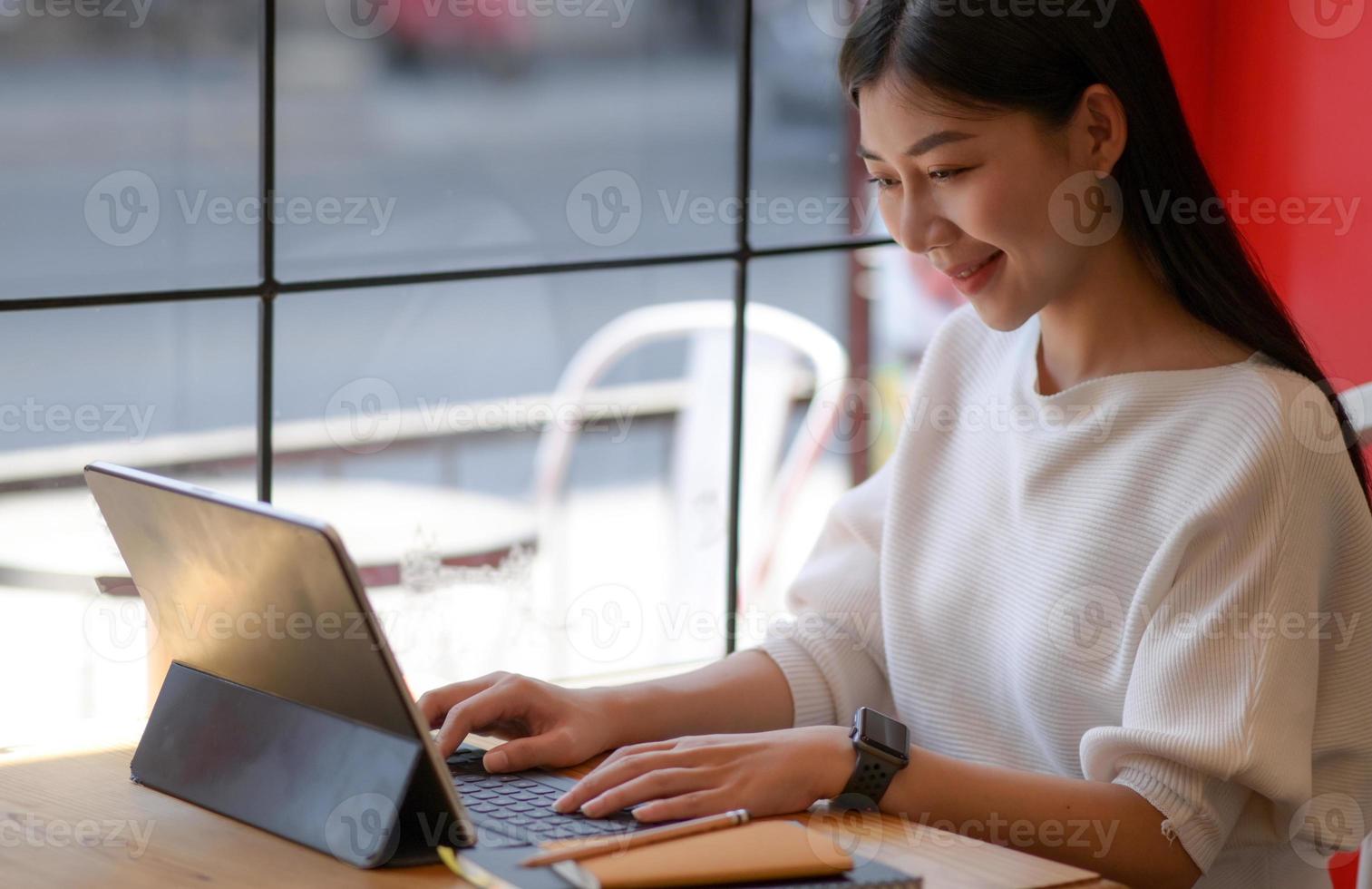 A young woman using a laptop with a smiling expression, she video online with friends. photo