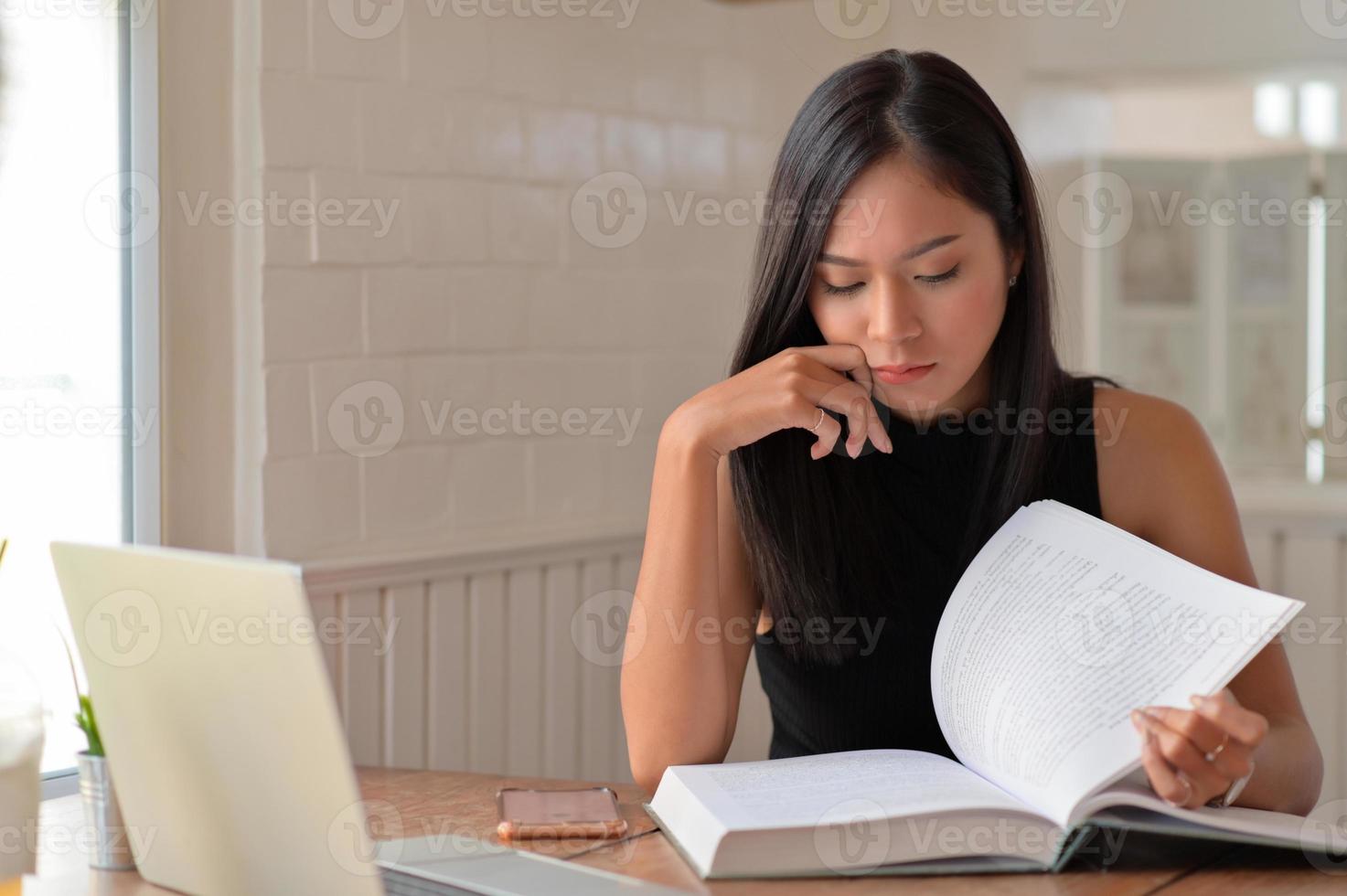 una mujer joven leyendo con una expresión seria, se estaba preparando para el examen de ingreso a la universidad. foto