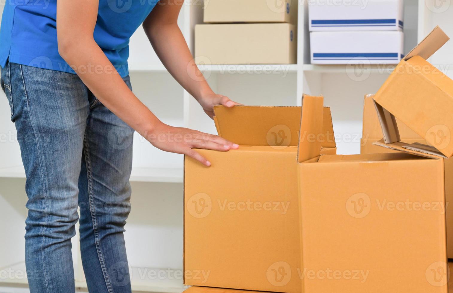 Courier is packing a brown box to prepare for delivery to the customer. photo