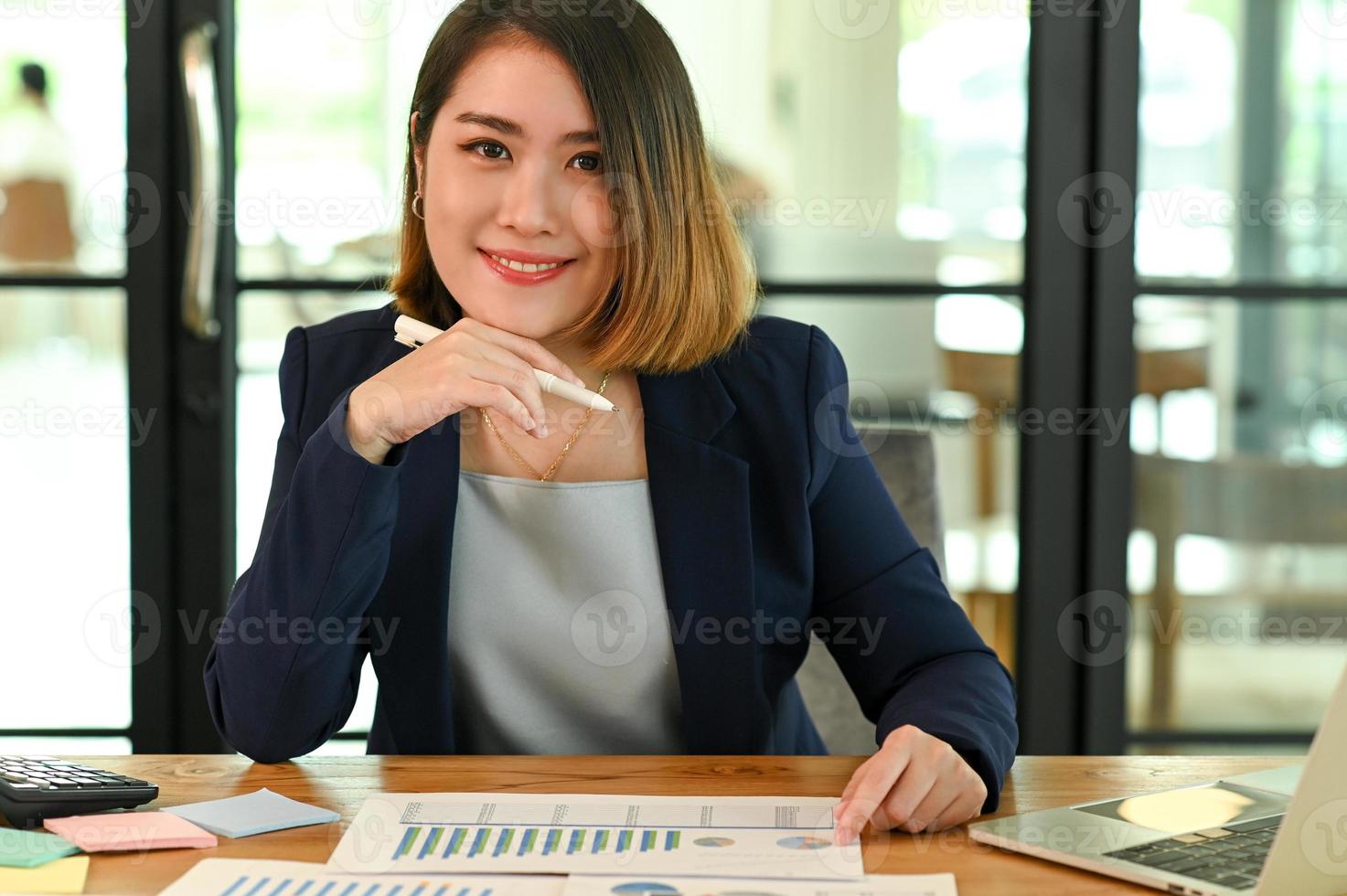 The Young businesswoman in a suit looking at the camera and smiling photo