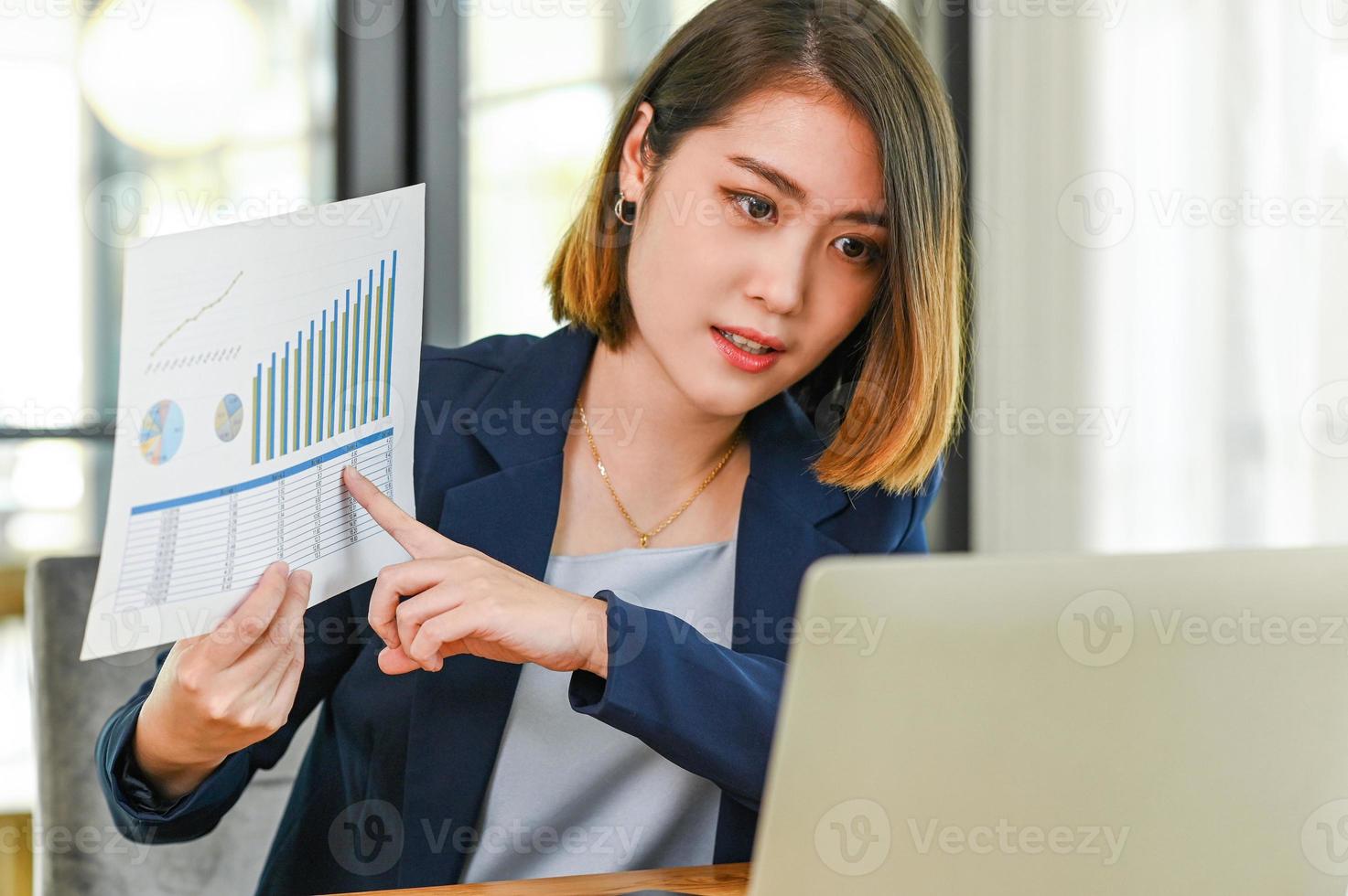 A female executive with data graph is meeting online. photo
