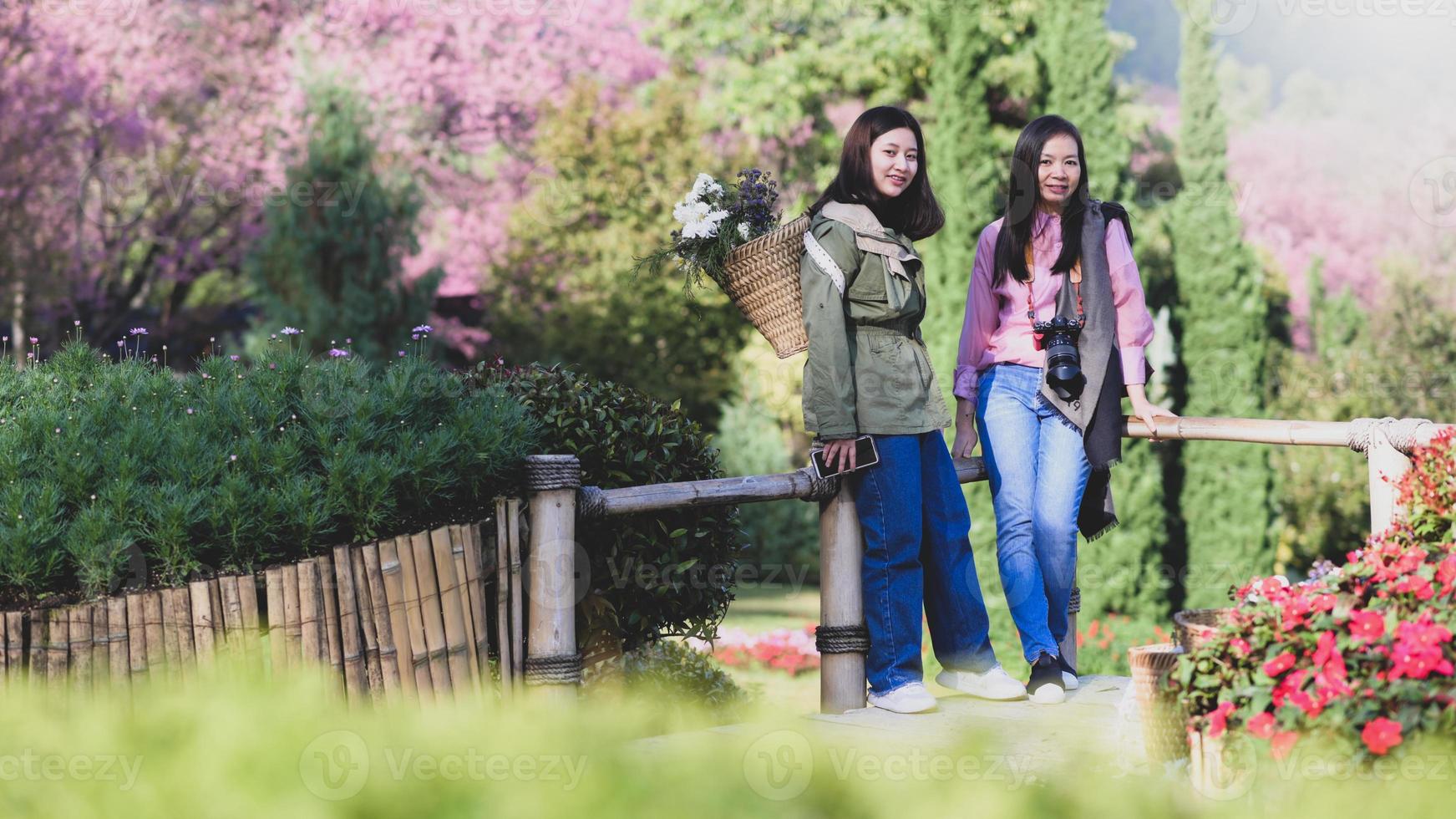 sonriente madre e hija asiáticas frente a la cámara en la naturaleza. foto