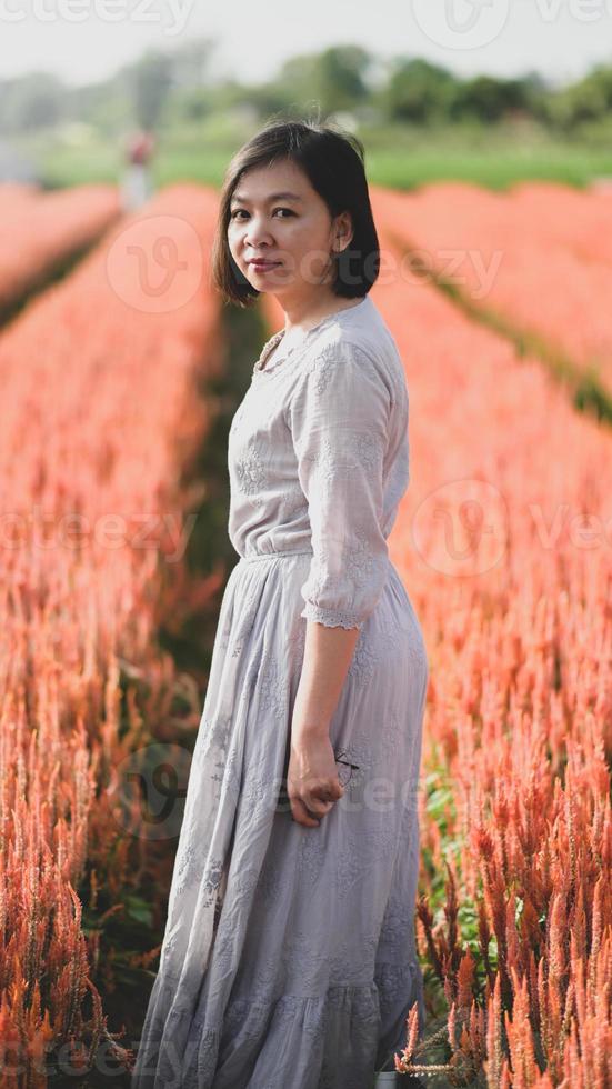 Asian woman happily walking and taking pictures in the flower garden. photo