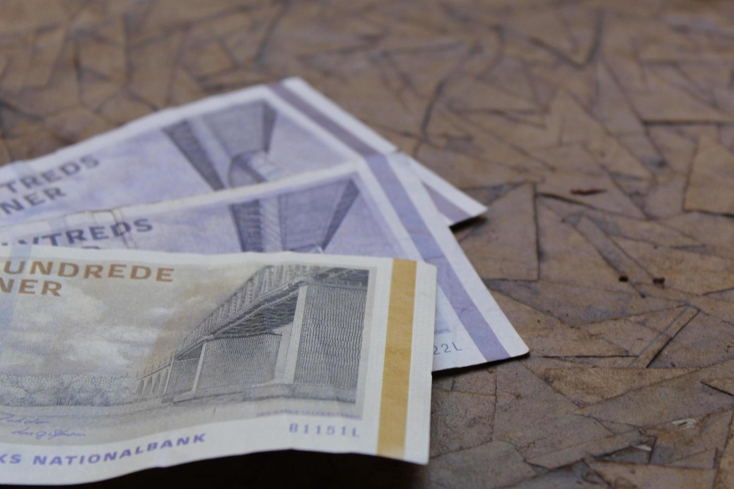 Billetes daneses apilados de diferente denominación en el cuadro marrón foto