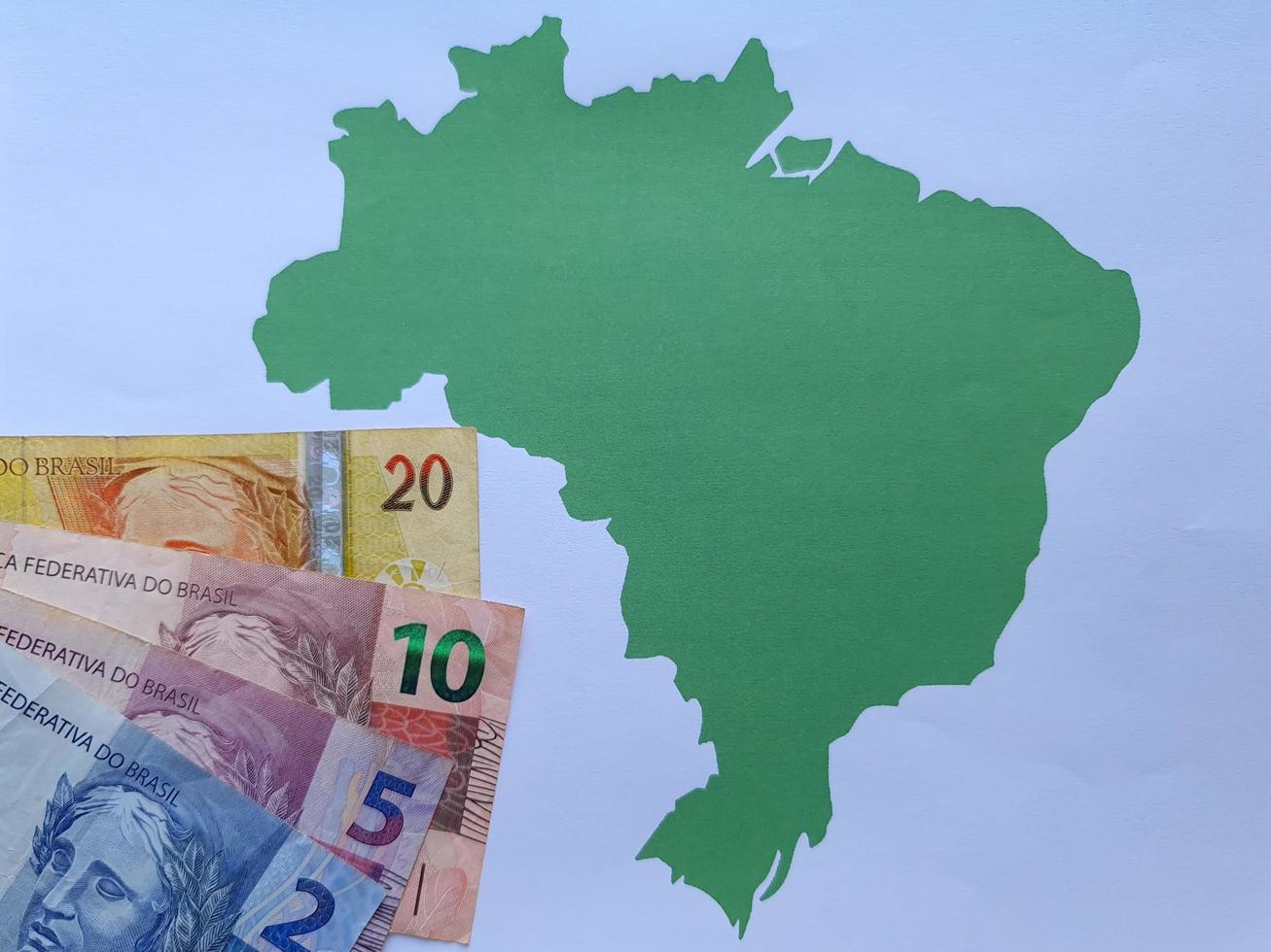 Billetes brasileños y fondo con silueta de mapa de Brasil foto