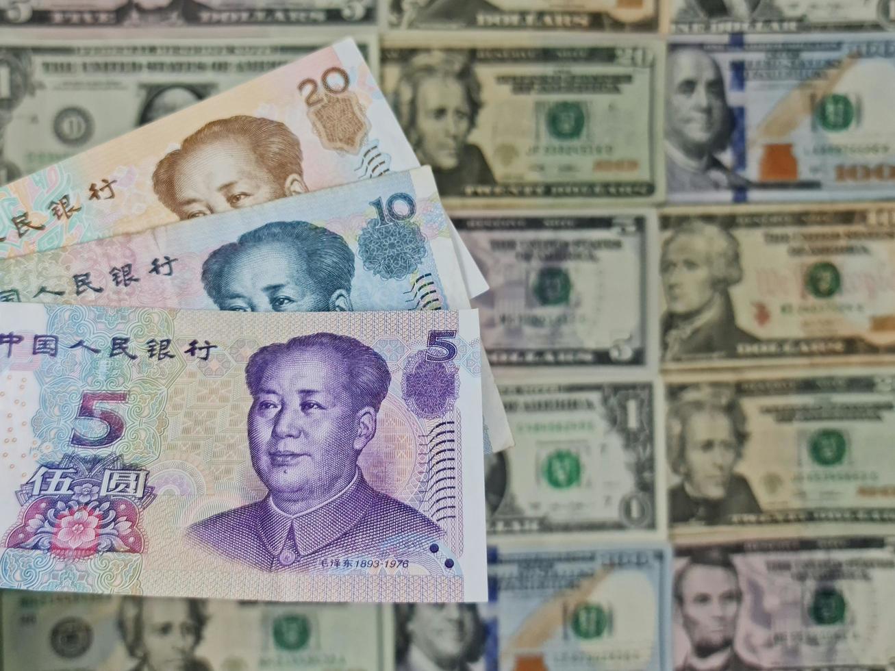 enfoque a los billetes chinos y antecedentes con billetes de dólar americano foto